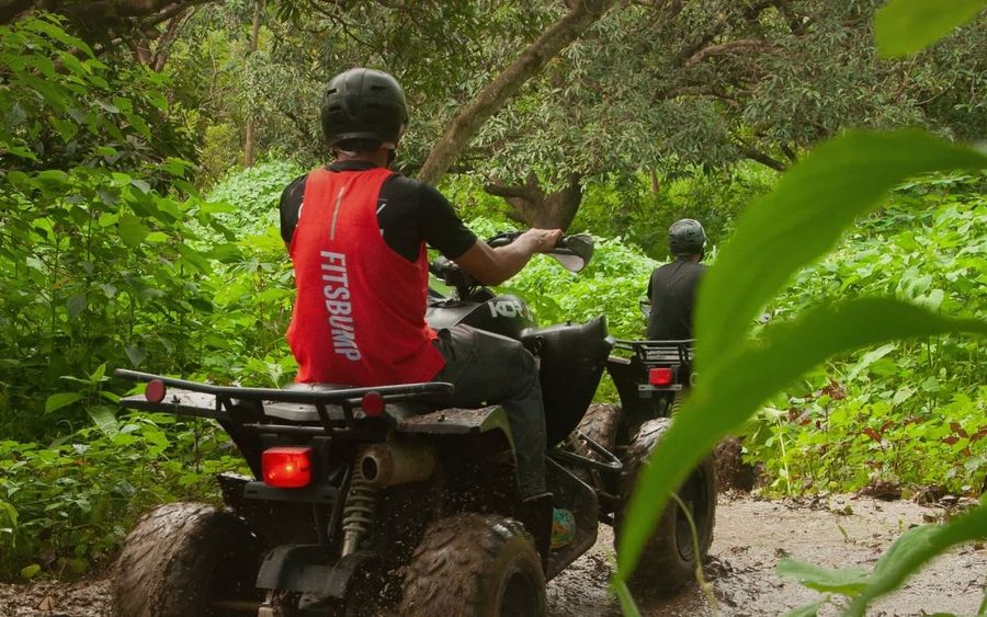 Rider on an ATV splashing through the off-road trail