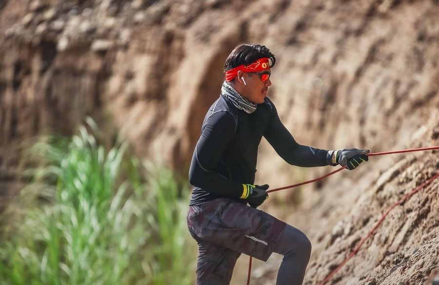 Climber on a rope up the Titans Trail earth wall