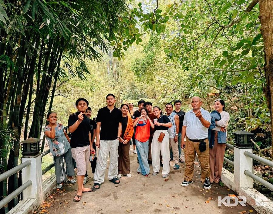 Team posing together on a forest path
