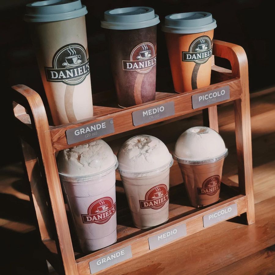 Daniel’s Coffee cups in Grande, Medio and Piccolo sizes on a wooden stand
