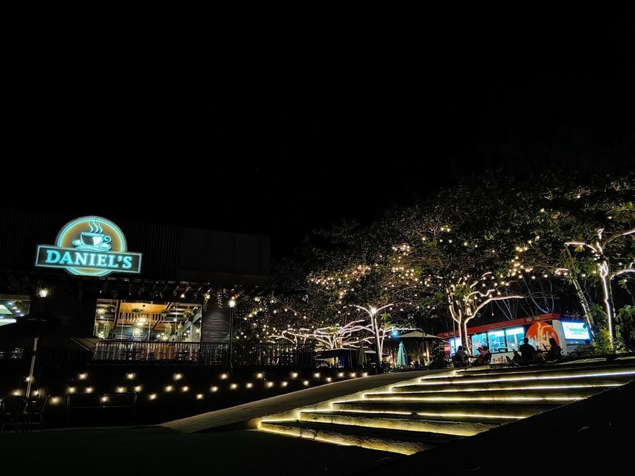 Daniel’s Coffee at night with the sign glowing and fairy lights over the stone steps