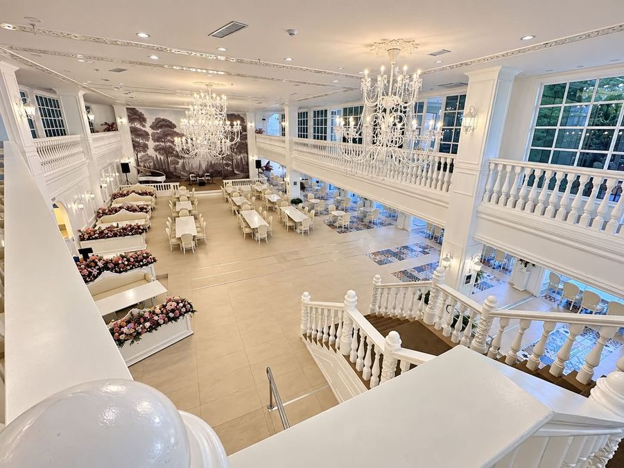 Dining hall seen from the mezzanine, with chandeliers and rows of tables