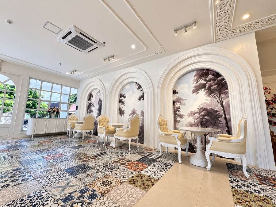 Arched mural alcoves, cream chairs and patterned tile floor