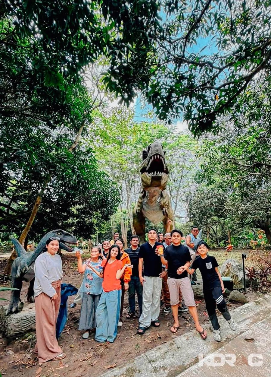 Group of visitors posing near the dinosaur statues at Dino Park