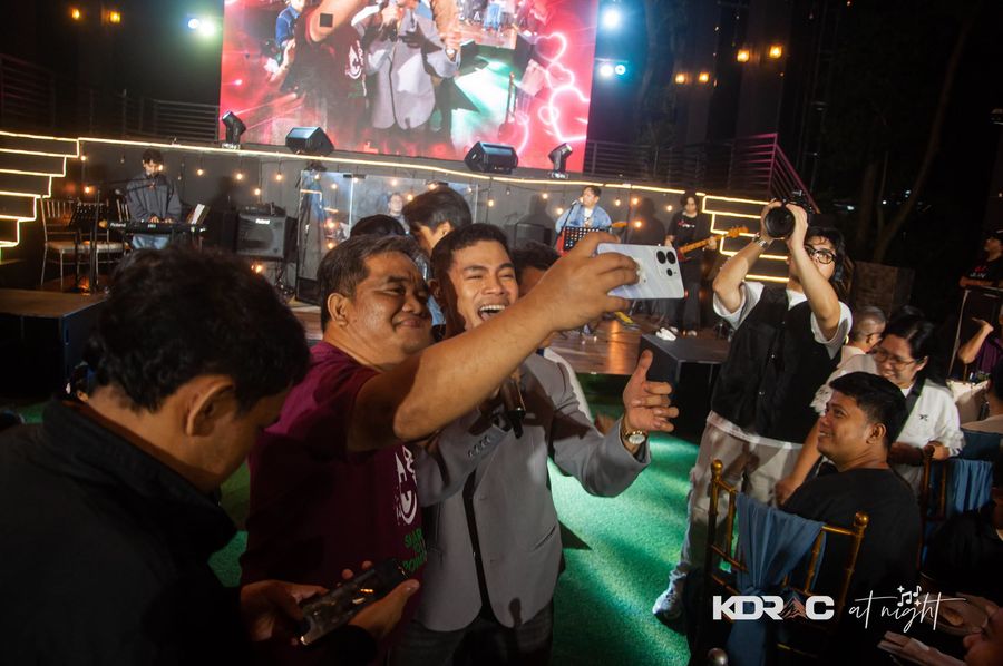 Guests crowding in for a selfie with the performer