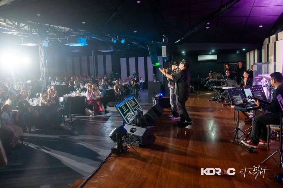 Performer on stage with the Events Hall full of diners