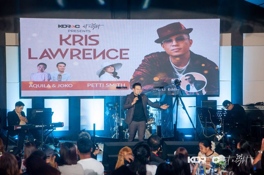 Kris Lawrence on the stage under his name on the big screen